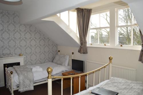 a bedroom with a bed and a desk with a computer at Ellerbrook House in Windermere
