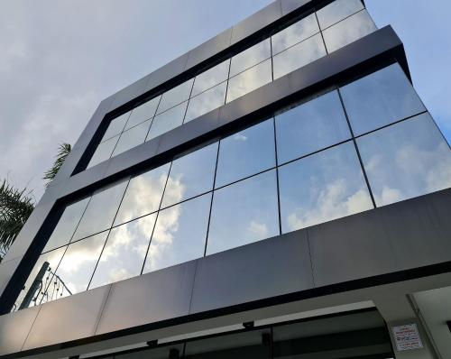 a glass building with the sky reflected in its windows at Seasons BC in Cabeçudas