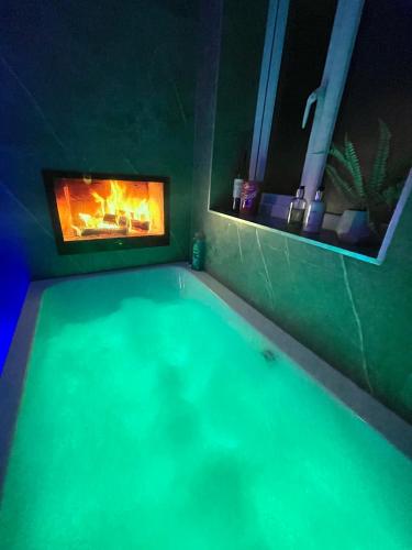 a swimming pool with a fireplace in a bathroom at The Lansdowne Hideaway - Brought to you by Coastline Retreats - Newly Refurbished Town centre, Close to beach, Large Jet bath with TV, Netflix, swing and Parking Included in Bournemouth