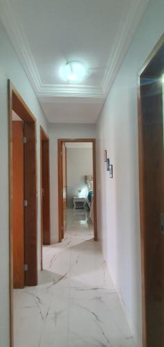 un pasillo de una habitación con una pared blanca en Luxuria Apartamento Palazzo di Italia en Goiânia