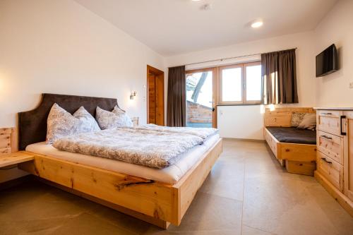 - une chambre avec un grand lit et une grande fenêtre dans l'établissement Unterkoller Bauernhaus Chalet, à Bischofshofen