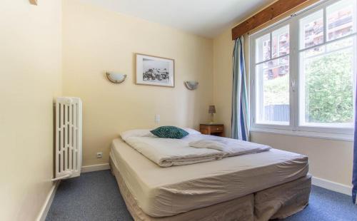a small bedroom with a bed and a window at Hotel Le Chamois in L'Alpe-d'Huez