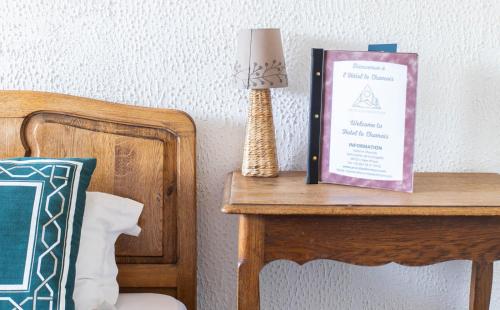 a table with a book on it next to a bed at Hotel Le Chamois in L'Alpe-d'Huez