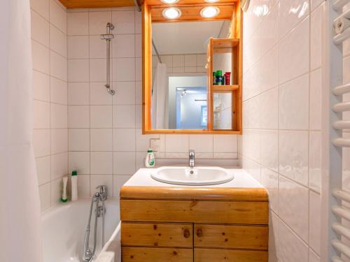 a bathroom with a sink and a tub and a mirror at Appartement skis aux pieds avec parking couvert et WiFi au cœur de Val d'Isère - FR-1-694-259 in Val dʼIsère