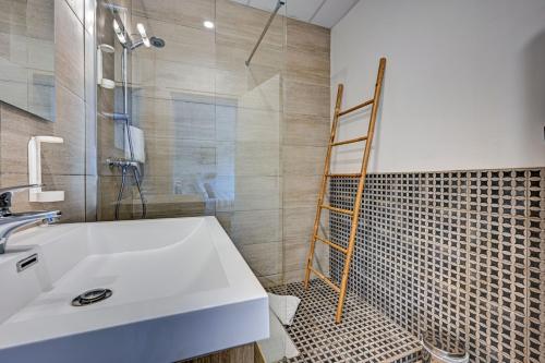 La salle de bains est pourvue d'un lavabo blanc et d'une échelle. dans l'établissement Le Provence, à Gémenos