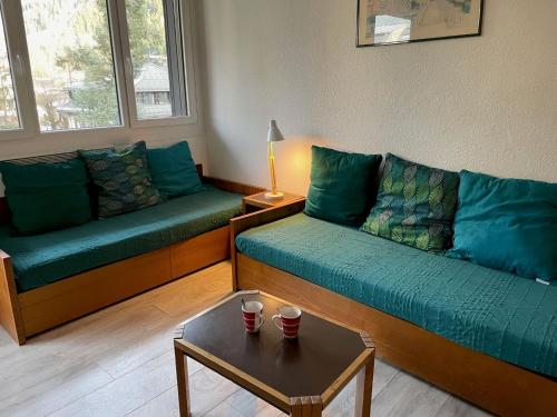 a living room with two couches and a table at Apartment Le Chamois Blanc-3 by Interhome in Chamonix
