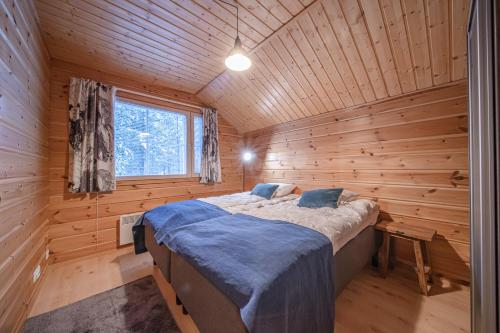 1 dormitorio con 1 cama en una cabaña de madera en Levillas Kätkänkuja 3 Villas, en Levi