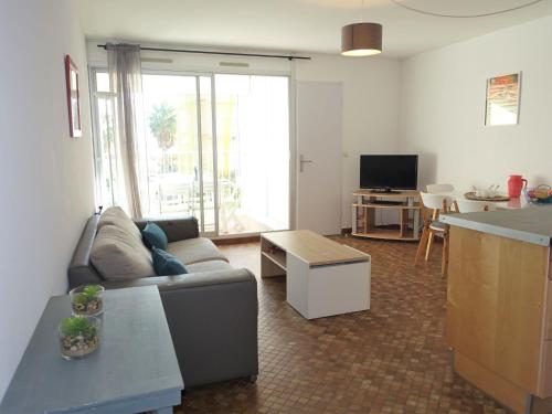 ein Wohnzimmer mit Sofa und Tisch in der Unterkunft Apartment Maisons sur la Plage-1 by Interhome in Gruissan
