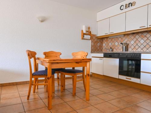 a kitchen with a wooden table and two chairs at Apartment Caroubier 2 by Interhome in Ovronnaz