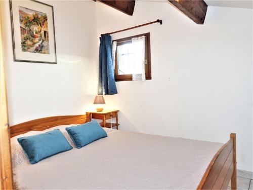 une chambre avec un lit avec des oreillers bleus dessus dans l'établissement Holiday Home L'Hacienda by Interhome, à Narbonne-Plage