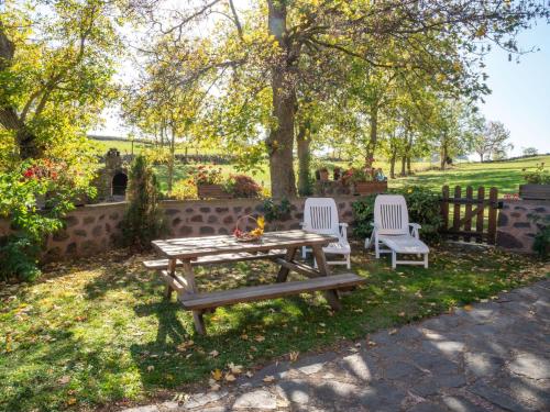 a picnic table and two chairs in a yard at Holiday Home ferme by Interhome in Agizoux