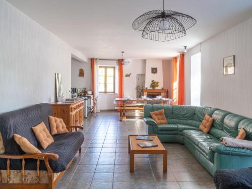 un soggiorno con un divano verde e un tavolo di Holiday Home ferme by Interhome a Agizoux