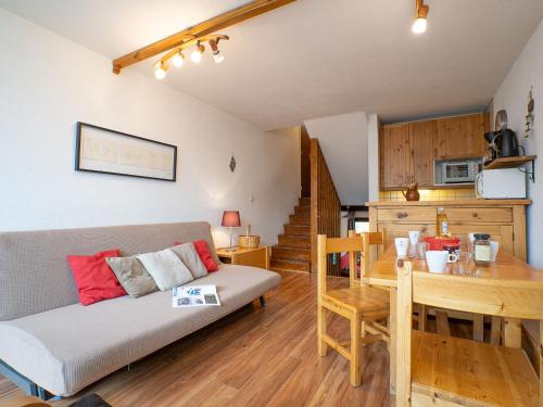 a living room with a couch and a table and a kitchen at Apartment Brelin-6 by Interhome in Les Menuires