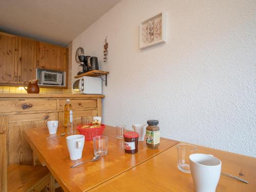 - une cuisine avec une table en bois et des verres dans l'établissement Apartment Brelin Côte Brune 613 by Interhome, aux Menuires