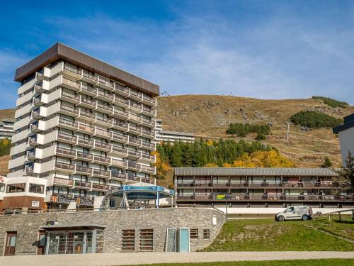 un grand bâtiment avec une voiture garée devant lui dans l'établissement Apartment Pelvoux-2 by Interhome, aux Menuires