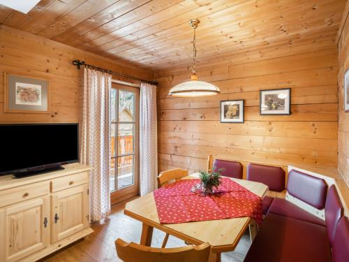 a dining room with a table and a tv at Chalet Gnadenalm - OBR103 by Interhome in Obertauern