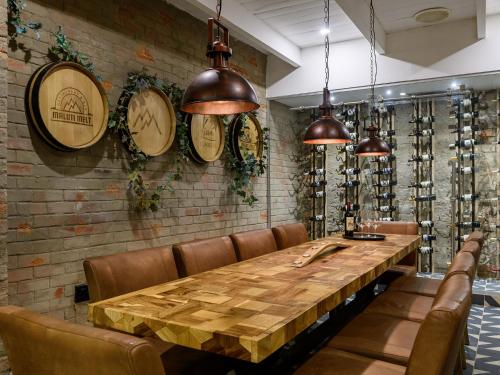 a dining room with a table and chairs and wine racks at Kiara Lodge in Clarens