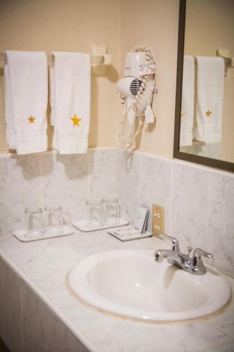 a bathroom counter with a sink and a mirror at Hotel Estrella in Managua