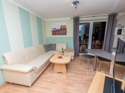 a living room with a white couch and a table at Apartment An der Eine-1 by Interhome in Stangerode