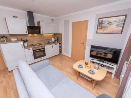 a living room with a couch and a table at Apartment An der Eine-3 by Interhome in Stangerode