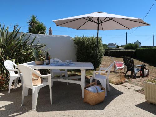 una mesa blanca y sillas con sombrilla en Holiday Home Balades au bord de l'eau by Interhome, en Plozévet