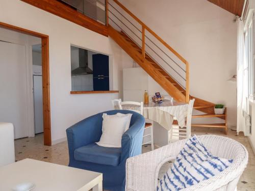 un salon avec une chaise bleue et une table dans l'établissement Holiday Home Balades au bord de l'eau by Interhome, à Plozévet