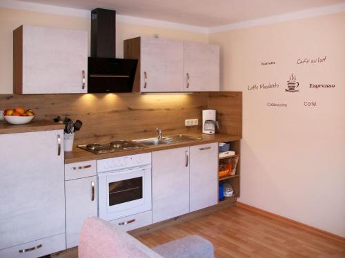 una cocina con armarios blancos y fregadero en Apartment An der Eine-2 by Interhome en Stangerode