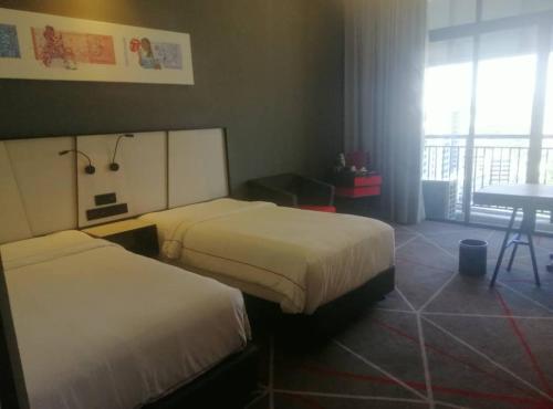 a hotel room with two beds and a table at The RED in Kuala Lumpur