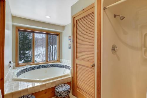 a bathroom with a tub and a window at The Hidden Chalet in Harbor Springs