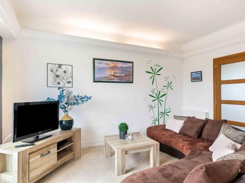 un salon avec un canapé et une télévision à écran plat dans l'établissement Holiday Home La Mouette by Interhome, à Kertissiec