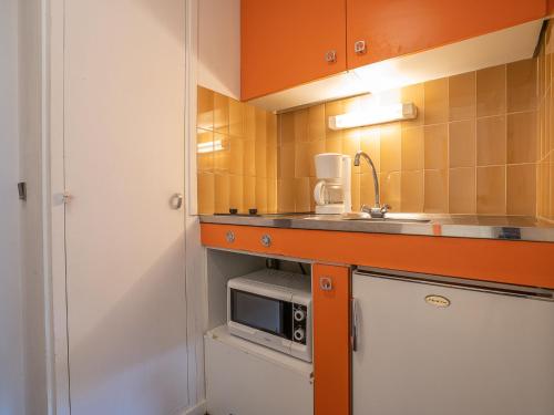 une petite cuisine avec un évier et un micro-ondes dans l'établissement Apartment Armoise 73 by Interhome, aux Menuires