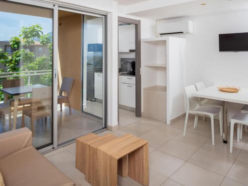 een woonkamer met een bank en een tafel bij Apartment MB4 piscine by Interhome in Moriani Plage