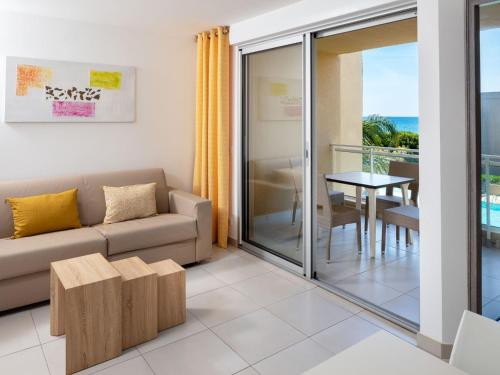 een woonkamer met een bank en een tafel bij Apartment MB4 piscine by Interhome in Moriani Plage