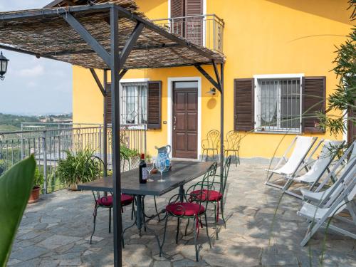einen Tisch und Stühle unter einem Sonnenschirm auf einer Terrasse in der Unterkunft Apartment San Michele-1 by Interhome in Vinchio