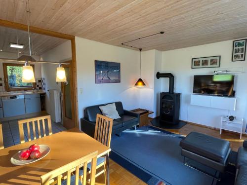 ein Wohnzimmer mit einem Tisch und ein Wohnzimmer mit einem Holzofen in der Unterkunft Holiday Home Westfalen by Interhome in Dittishausen