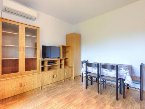 a room with a table and chairs and a tv at Apartment Vesela-3 by Interhome in Savudrija