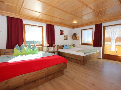 1 dormitorio con 2 camas y cortinas rojas en Apartment Anita-3 by Interhome en Zellberg