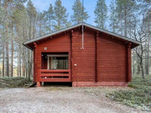 eine Holzhütte mit einem großen Fenster in einem Wald in der Unterkunft Holiday Home Viipusjärvi 10 by Interhome in Ruka
