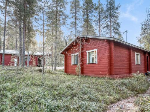 eine rote Hütte mitten im Wald in der Unterkunft Holiday Home Viipusjärvi 10 by Interhome in Ruka