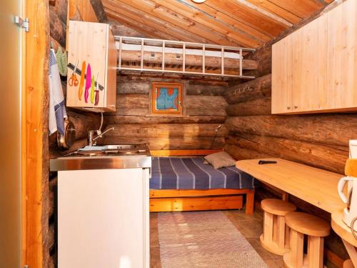 a kitchen with a bed and a table in a cabin at Holiday Home Saarenkainalo by Interhome in Ruka