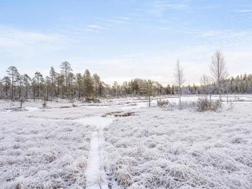 ein schneebedecktes Feld mit Bäumen im Hintergrund in der Unterkunft Holiday Home Pajalan honka by Interhome in Kuusamo