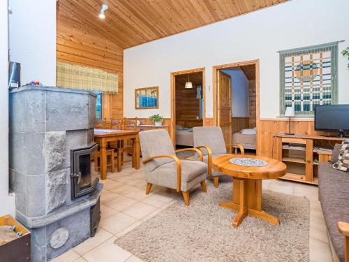 a living room with a fireplace and a table at Holiday Home Villa kuukso by Interhome in Kuusamo