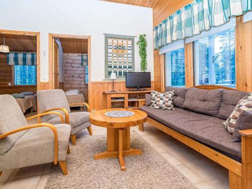a living room with a couch and chairs and a tv at Holiday Home Villa kuukso by Interhome in Kuusamo