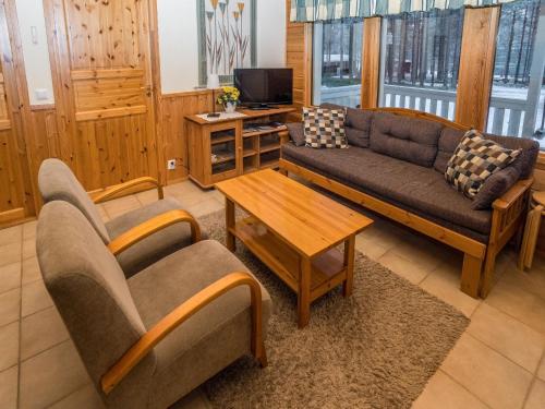 a living room with a couch and a table at Holiday Home Villa kuusanka by Interhome in Kuusamo
