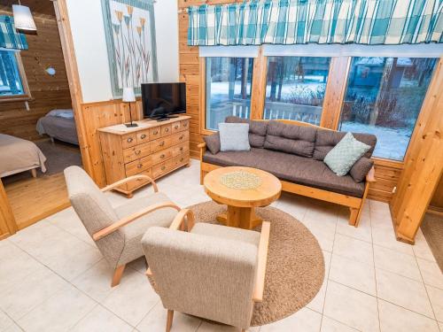a living room with a couch and a table and chairs at Holiday Home Villa hilla by Interhome in Kuusamo