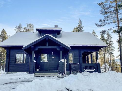 a blue house with a snow covered roof at Holiday Home Utsunusko a by Interhome in Levi