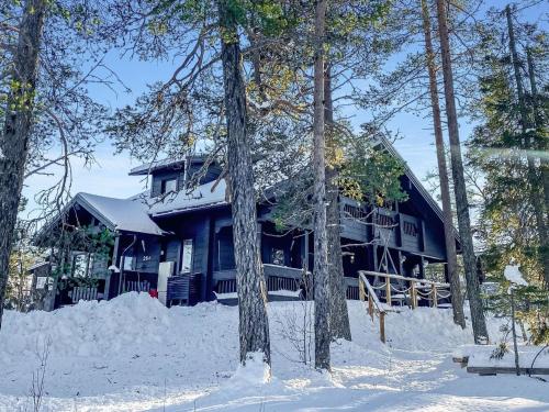 a blue house in the snow with trees at Holiday Home Utsunusko a by Interhome in Levi