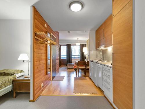 uma cozinha com armários de madeira e uma cama num quarto em Holiday Home Ylläs chalets 2405 by Interhome em Ylläs
