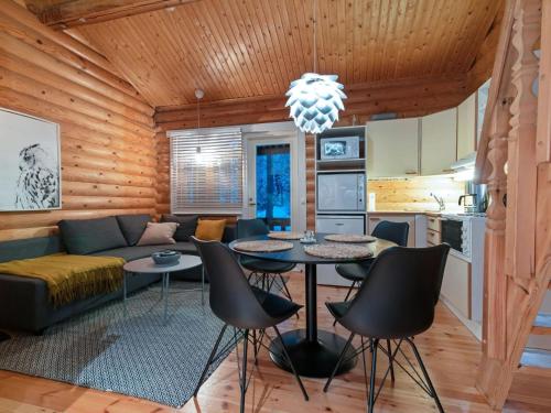 uma sala de estar com um sofá, uma mesa e cadeiras em Holiday Home Felixinpolku 2 by Interhome em Ylläsjärvi