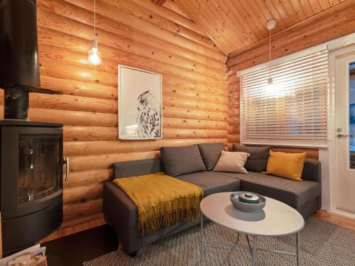 a living room with a couch and a fireplace at Holiday Home Felixinpolku 2 by Interhome in Ylläsjärvi